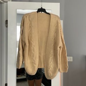 Cream colored, oversized sweater cardigan.